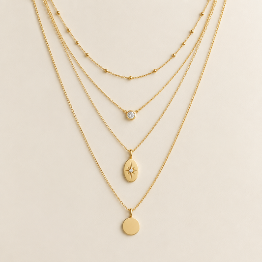 Layered gold necklace set on ivory background
