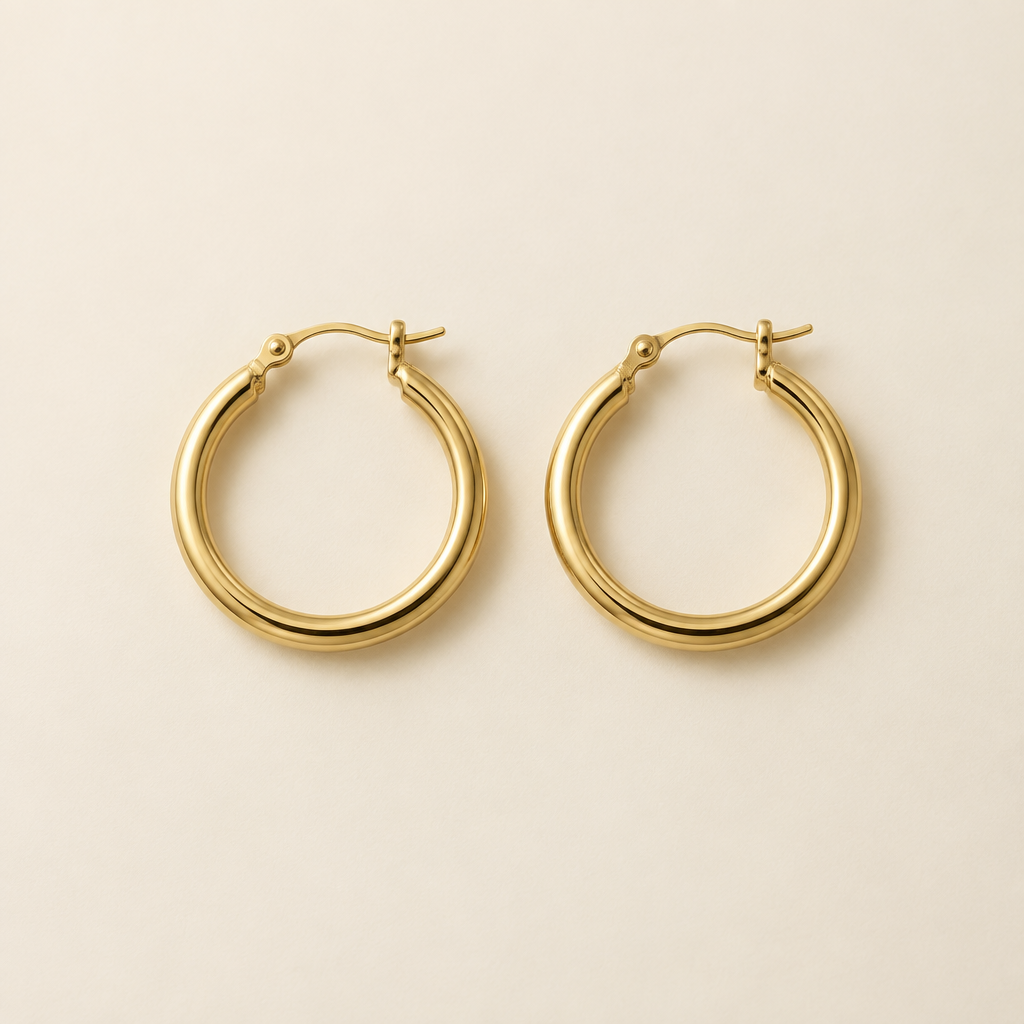 Pair of classic gold hoop earrings on ivory background